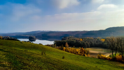 Green fields on hills and and Ostrzyckie Lake in a background.
