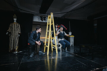 A scene from a theatrical performance showcasing young actors in diverse roles, dramatic costumes,...