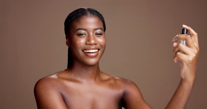 Beauty, makeup and woman spray face in studio for foundation, setting concealer and natural glow. Mockup, black person and happy with cosmetic mist application for skin hydration on brown background