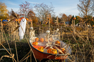 Funny Halloween decoration with ghost and skeletons in boat