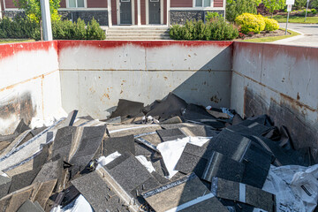 Roofing shingles damaged by hailstorm in garbage bin