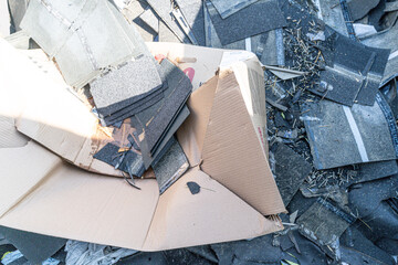 Roofing shingles damaged by hailstorm in garbage bin