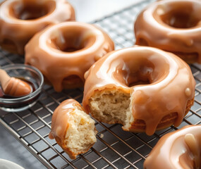 Delicious glazed donuts cooling on a wire rack, inviting sweet indulgence and perfect for an afternoon treat shared with friends