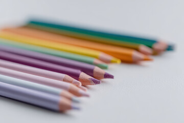 Fototapeta premium Colorful pencils arranged on white surface, creating vibrant display