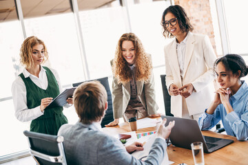 Group of colleagues collaborating in an office setting engaging in teamwork and showcasing...