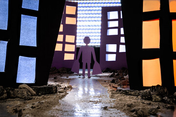 Conceptual image of a man carrying shopping bags walking on a dirt and rock-covered path through a...