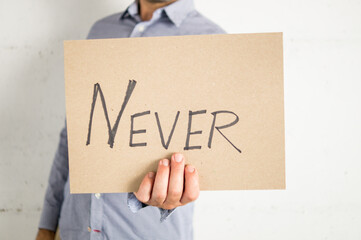 Person showing a sign that says never
