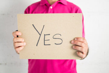 Person wearing a pink t-shirt showing an affirmation sign