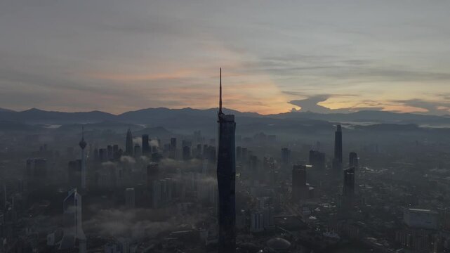 Establishing aerial cinematic b-roll shot of sunrise at Kuala Lumpur city skyline with highest building in Asia