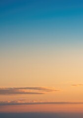 Naklejka premium Vibrant sunset sky with blue-orange gradient, minimal clouds below, clean background, high resolution, peaceful mood. 