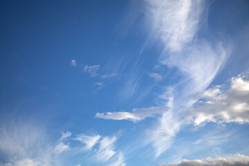 White cirrus clouds against a blue summer sky