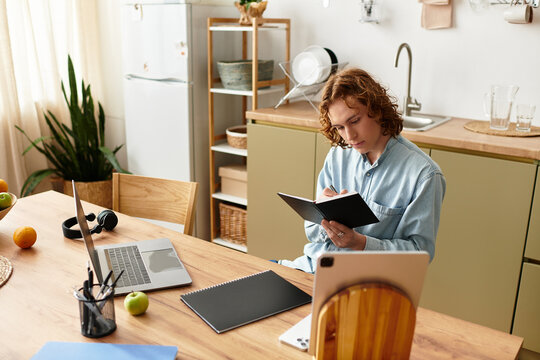 Handsome young man engages in creative writing at home during a relaxed afternoon