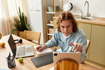 Handsome young man engaged in focused study at home with casual decor and modern technology