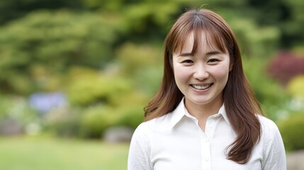 Fototapeta premium Woman with beautiful smiling face, white teeth, straight hair, wearing a white shirt on a green background, clear, high-resolution professional portrait with vivid details.