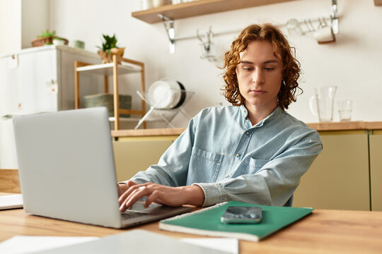 Young man working on laptop at home, focused and engaged in his task, enjoying a calm atmosphere