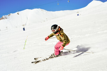 Dynamic sports woman skier wear colorful ski suit isolated ski downhill fast motion in Alps. Active...