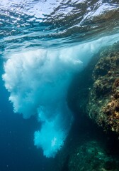 Fototapeta premium Underwater View of a Breaking Wave Near a Rocky Reef