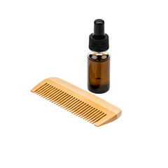 Wooden beard comb and dropper bottle of beard oil on transparent background