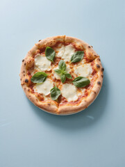 Delicious Margherita pizza with fresh basil, melted mozzarella, and tomato sauce on a light blue background. Perfect for food lovers!