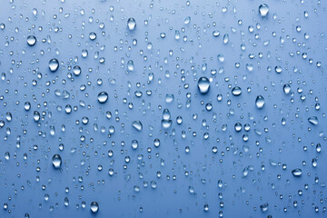 Water droplets on glass with blue background