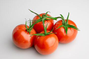 Fresh ripe tomatoes on vine isolated on white background