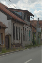 An old, abandoned roadside building with cracked walls and a plethora of overgrown greenery...