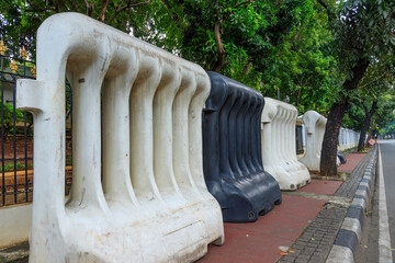 A set of giant plastic water-filled barriers on the sidewalk, commonly used for demonstration, road...