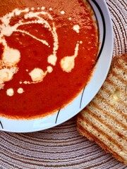 A photo of a bowl of red tomato cream soup