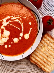 A photo of a bowl of red tomato cream soup