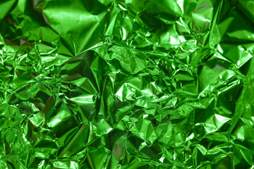 Bright green metallic foil texture creates an abstract and vibrant background for various creative projects
