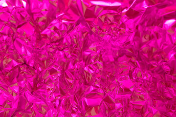 Vibrant textured pink foil surface reflecting light at close range creating an eye catching visual effect