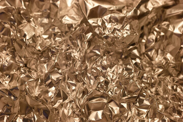 Shimmering crumpled foil texture with intricate patterns visible in golden shades