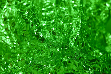 Shimmering green foil creating an abstract texture in a well lit environment during the daytime