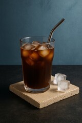 Iced Coffee with Ice Cubes in Glass with Stainless Steel Straw, set against a subtle and sophisticated backdrop
