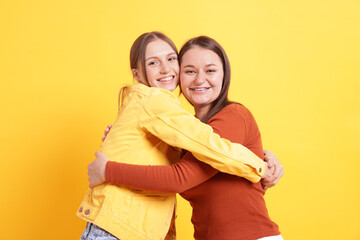 Friends hugging each other on orange background