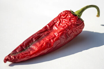 Food photography of a sleek, red chili, emphasizing its natural shape and vibrant hue.