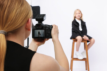 Photographer working with model in professional photo studio, selective focus