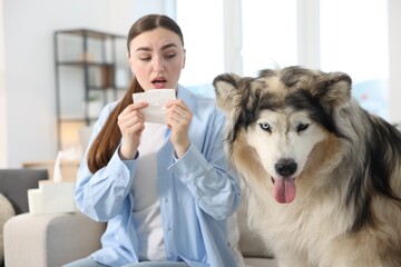 Woman suffering from allergy with her dog at home