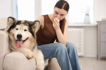 Woman suffering from allergy with her dog at home