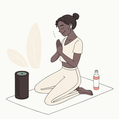 A woman meditating on a yoga mat with an aroma diffuser and essential oil bottle in a serene setting