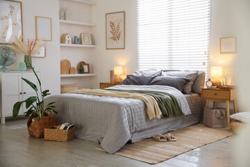 Comfortable bed with soft linens and blankets in room. Home textile