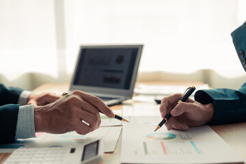 Business people discussing, there are financial charts and graphs on the table, discussing about...