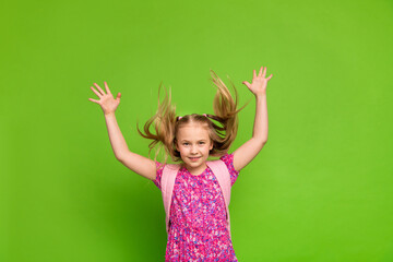Joyful young girl wearing a colorful dress smiling and expressing excitement against a vibrant...