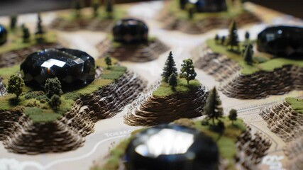 Miniature terrain model with hills, trees, and game pieces - Powered by Adobe