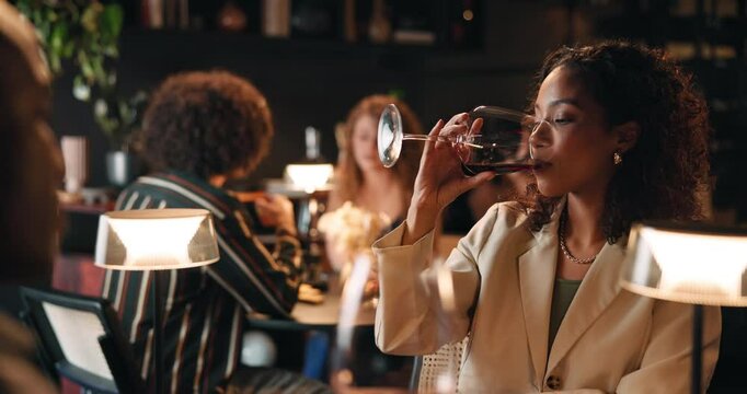Woman, night and drinking wine in restaurant with date for romantic dinner, anniversary or occasion. Female person, man or tasting alcohol in late evening with meal for fine dining or rendezvous