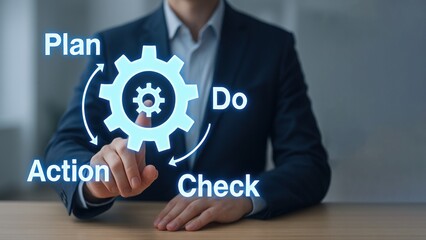 Businessman pointing on a glowing cycle words plan do check action with gears, symbolizing improvement and production planning and control focus