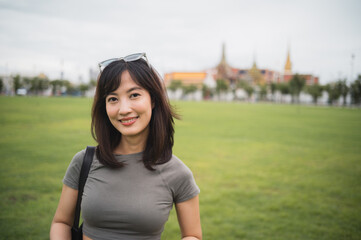 Happy solo Southeast Asian woman teenager blogger on world travel enjoys local cultural tourism...