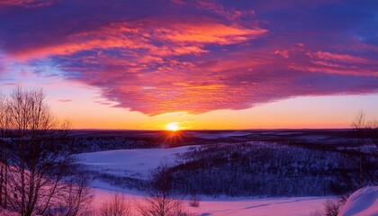 a vibrant sunset over a snowy landscape with pink purple and orange hues in the sky and clouds the sun is low on the horizon casting a warm glow over the scene