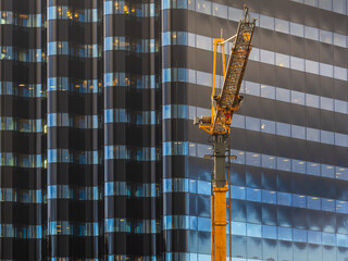 Crane working in front of iconic curved building in Gothenburg during early morning light