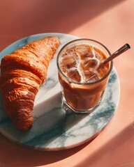 Croissant and a glass of iced coffeele table